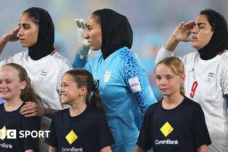 Previously silent Iran players sing and salute anthem